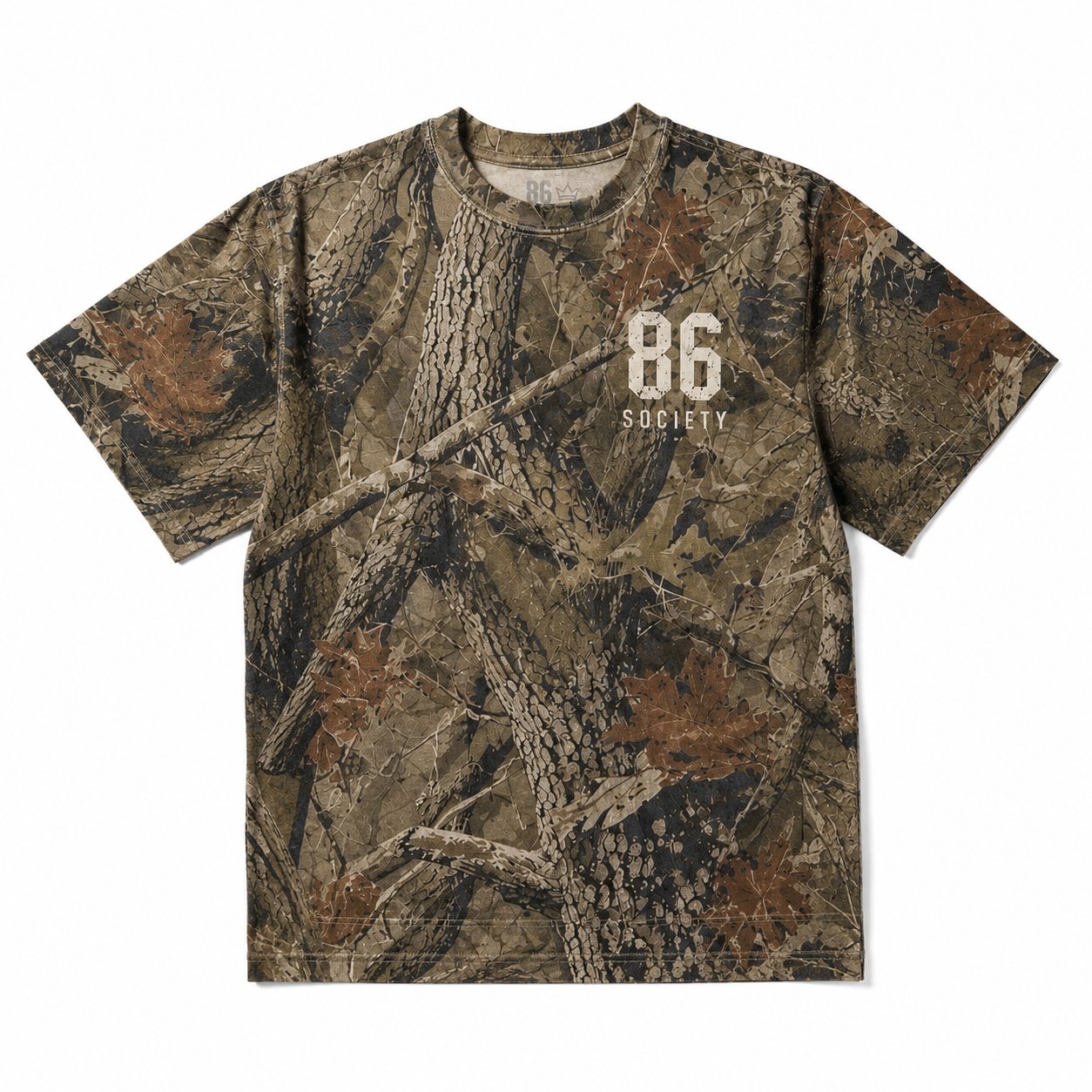 A short-sleeve crewneck t-shirt featuring a detailed woodland camouflage pattern with branches, leaves, and bark. The front has a white printed graphic reading '86 SOCIETY'.